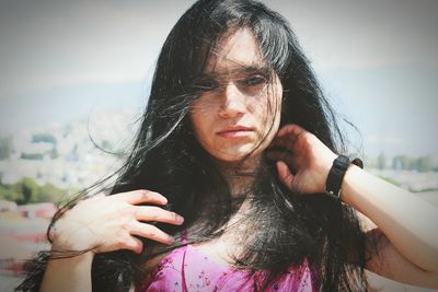 Close-up of young woman against sky