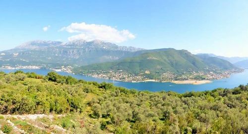 Scenic view of river and mountains against sky