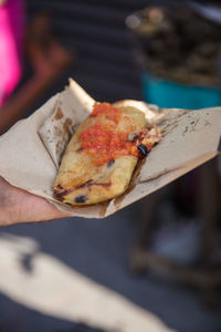 Close-up of hand holding pizza