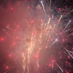 Low angle view of firework display at night