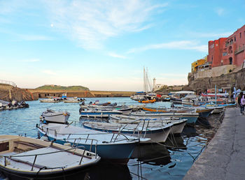 Boats moored in harbor against buildings in city