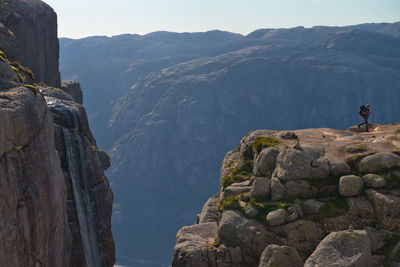 Man on rocks by mountains