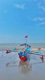 Man kayaking on sea against sky