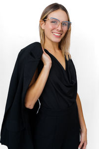 Portrait of young woman standing against white background