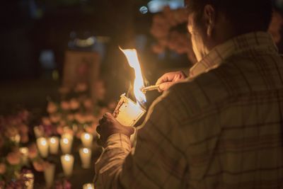 People holding burning candle