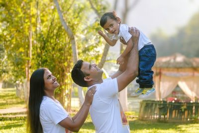 Side view of mother and daughter standing in park