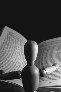 Close-up of figurine with book