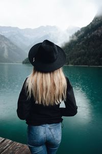 Rear view of woman standing at lake