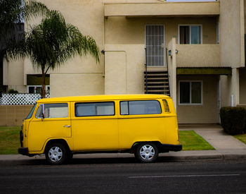 Yellow car parked on street against building
