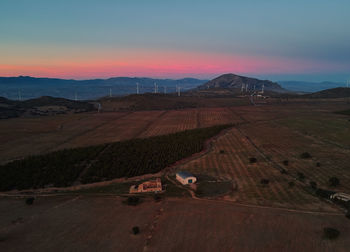 Scenic view of agricultural field against sky during sunset