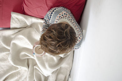 High angle view of boy lying on bed