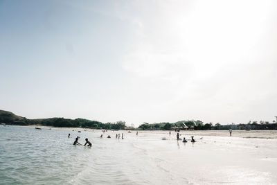 People on beach against sky
