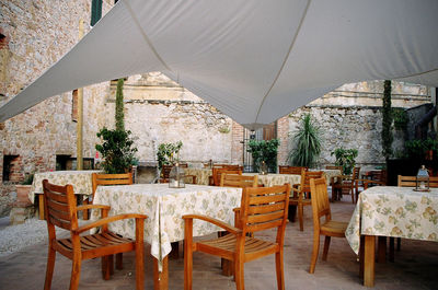 Empty chairs by tables at restaurant