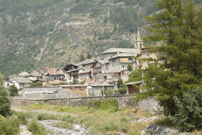 Houses amidst trees and buildings against mountains