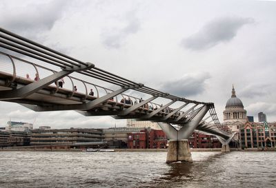 Bridge over water in city against sky