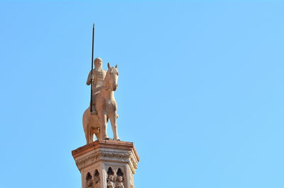 Low angle view of statue against blue sky