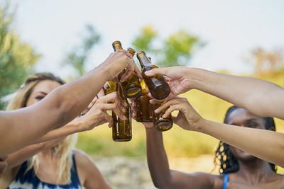 Close-up of group of female friends toasting with beer