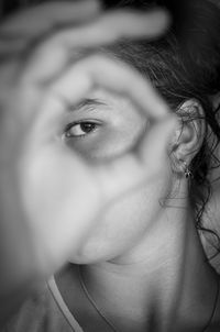 Close-up portrait of girl gesturing ok sign