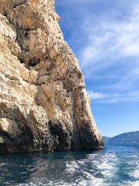 Rock formation in sea against sky