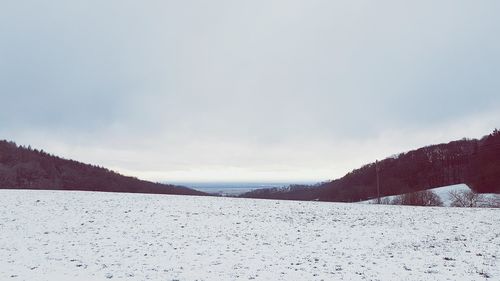Snow covered land against sky
