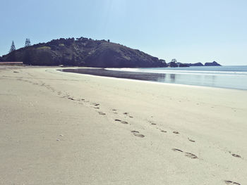 View of calm beach against clear sky