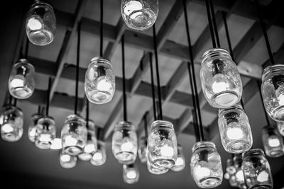 Low angle view of illuminated light bulbs hanging