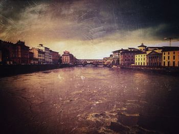 Buildings in city against cloudy sky