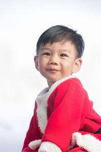 Portrait of cute smiling boy against white background