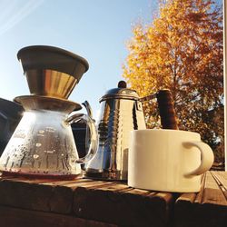 Close-up of coffee cup on table against sky