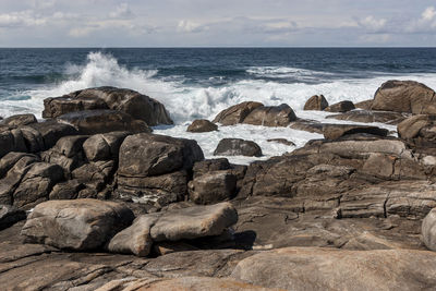 Rocks on beach against sky