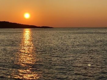 Scenic view of sea against clear orange sky