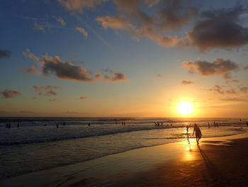 Silhouette man standing on beach against sky during sunset