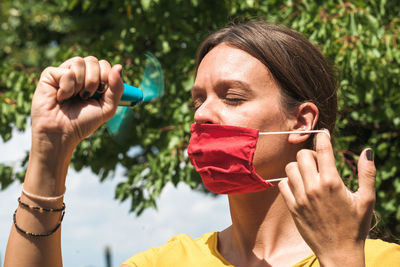 Close-up woman using hand fan