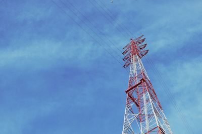 Low angle view of electricity pylon against blue sky