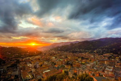 Aerial view of illuminated cityscape against sky during sunset