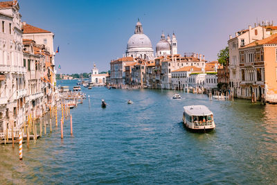 Boats in canal amidst buildings in city