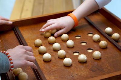 Cropped hands of people playing with wooden spheres