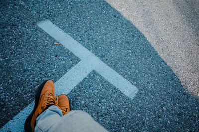 Low section of man standing on road