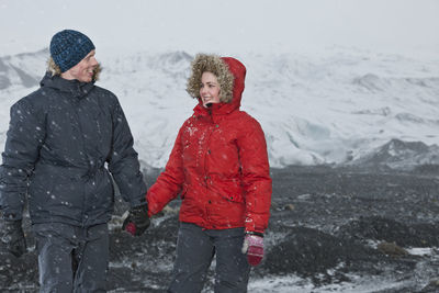 Young couple walking through snowstorm in iceland