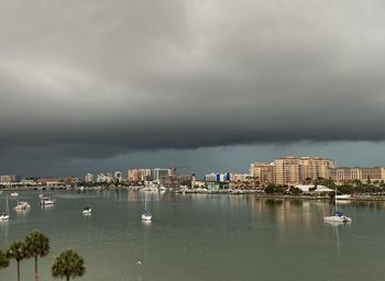 City buildings by sea against sky