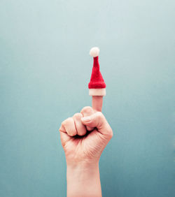 Close-up of hand holding ice cream against white background