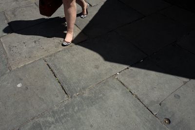 Low section of man walking on cobblestone
