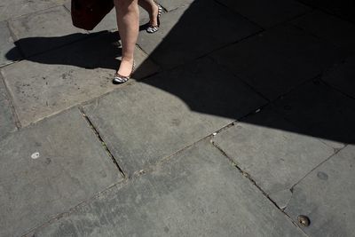 Low section of woman walking on footpath