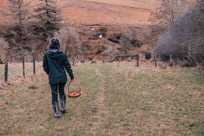 Rear view of man walking on field