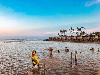 People at beach against sky