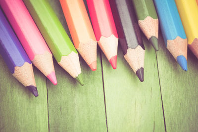 Directly above shot of colored pencils on wooden table