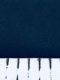 Snow covered field against sky at night