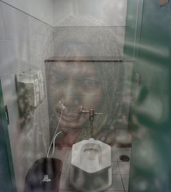 Digital composite image of man photographing through window