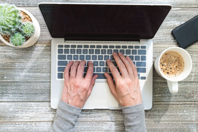 High angle view of man using laptop on table