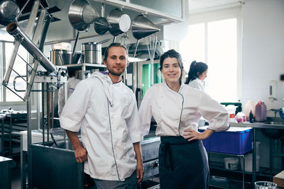 Portrait of confident chefs standing in commercial kitchen